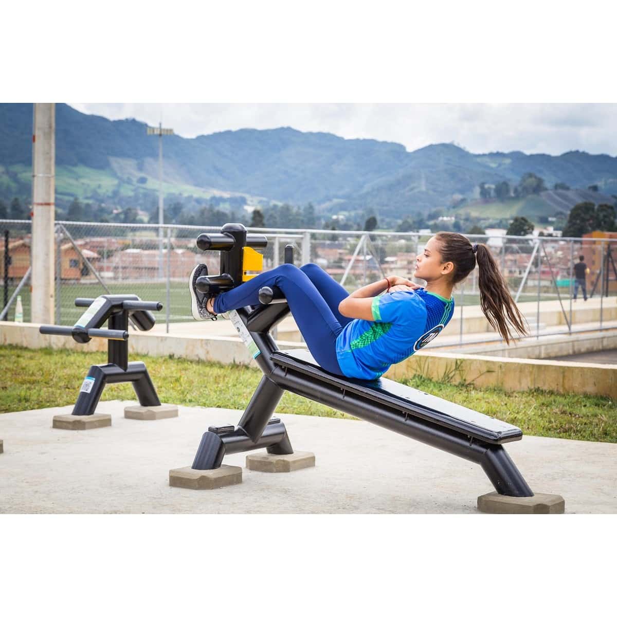 Mujer haciendo abdominales en la banca abdominal inclinada de TMGYM