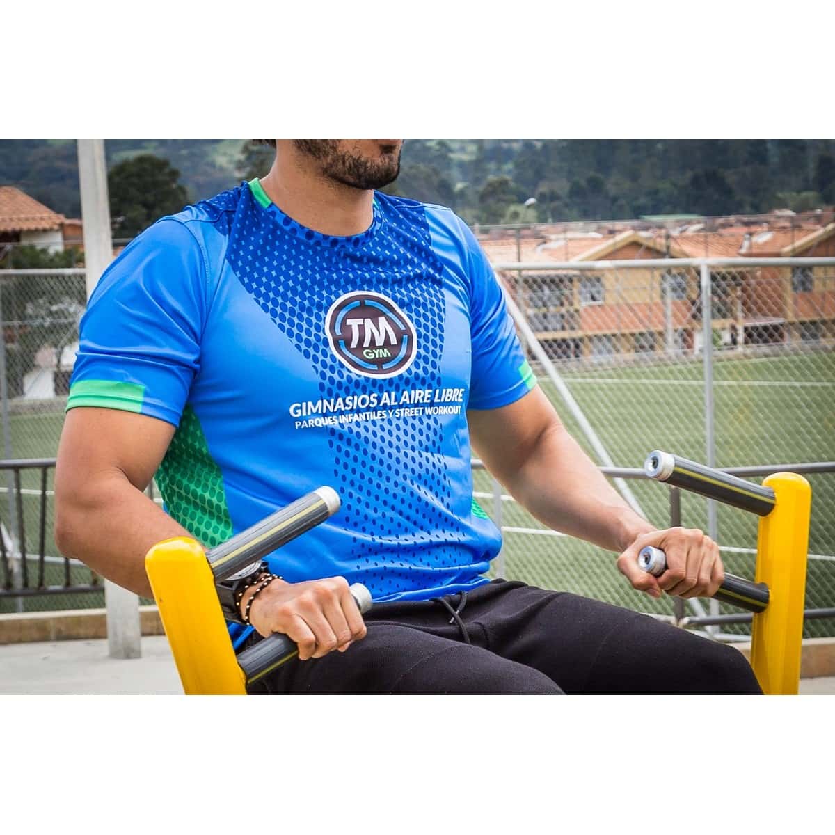 Hombre con camiseta de TMGYM tomando los agarres del Remo