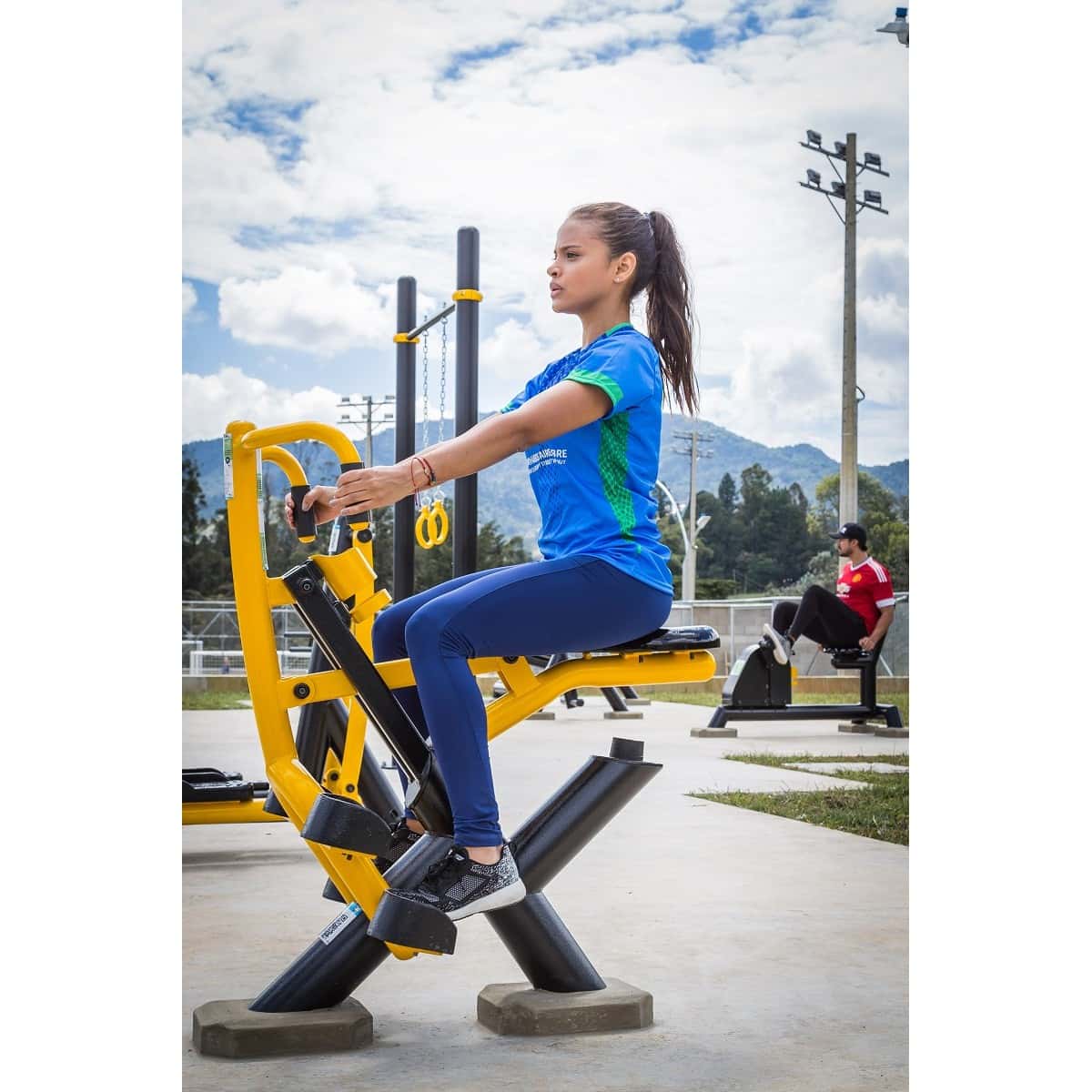 Mujer en el Jinete de TMGYM con agarres amarillos, vista lateral