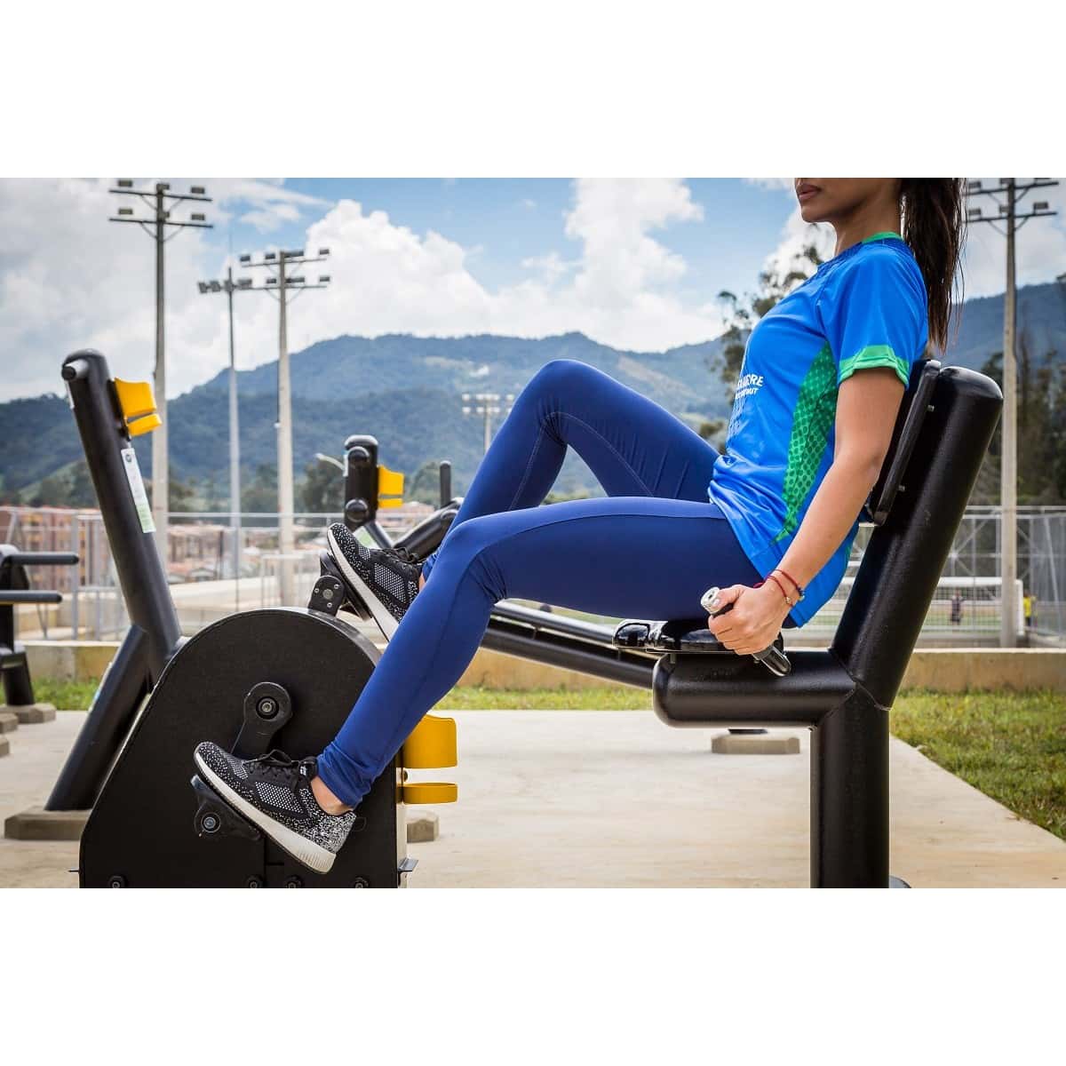 Mujer usando la bicicleta recumbent de TMGYM, vista lateral