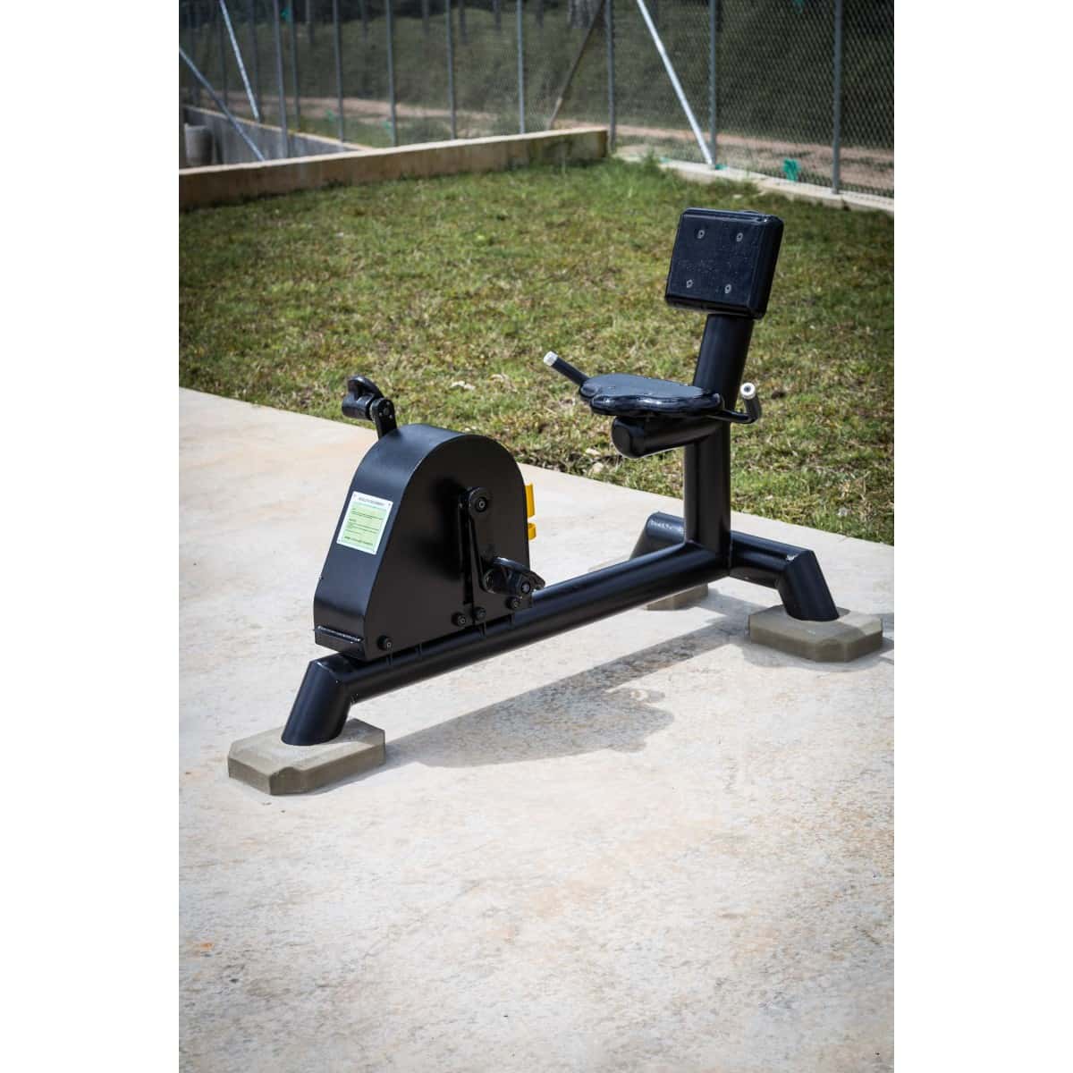 Bicicleta recumbent de TMGYM instalada sobre concreto en un parque