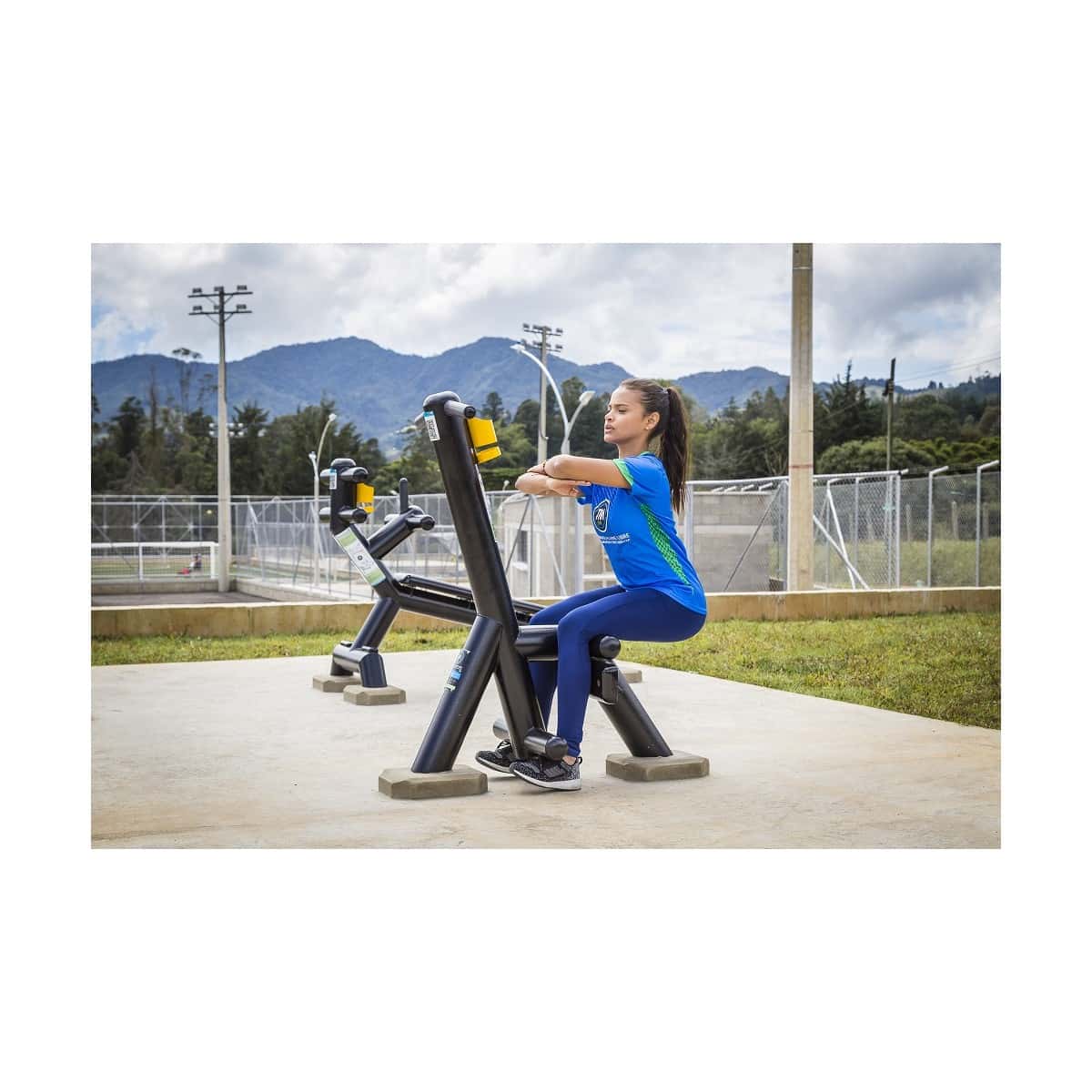 Mujer usando el calentador de piernas sissy de TMGYM en un parque deportivo