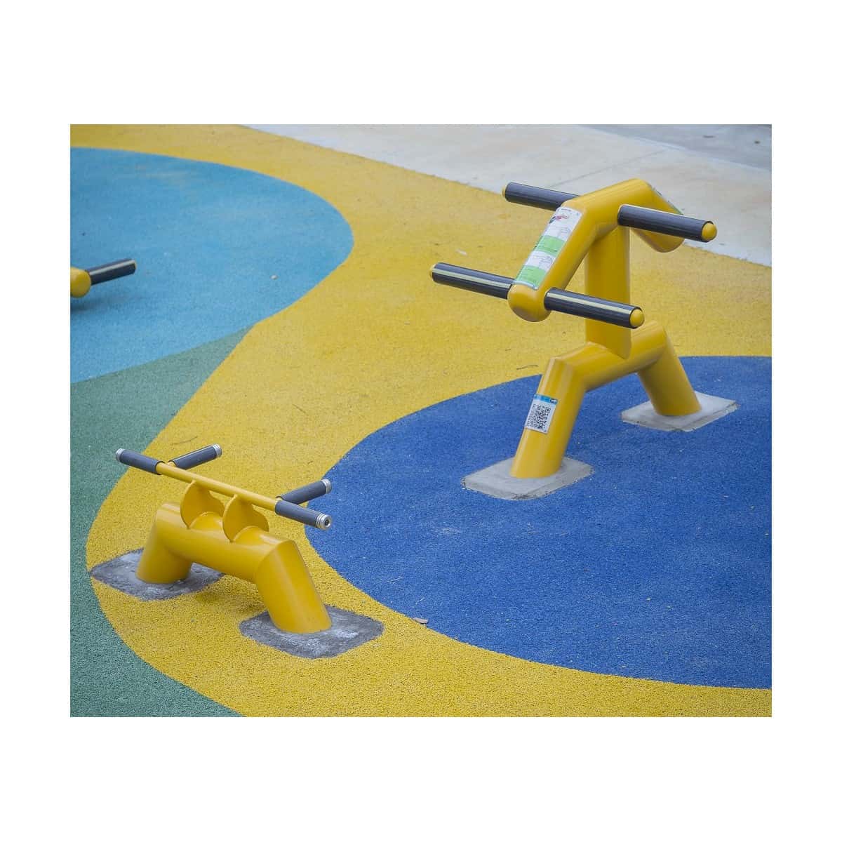 Flexión de pecho y tríceps de TMGYM sobre piso de colores en un parque