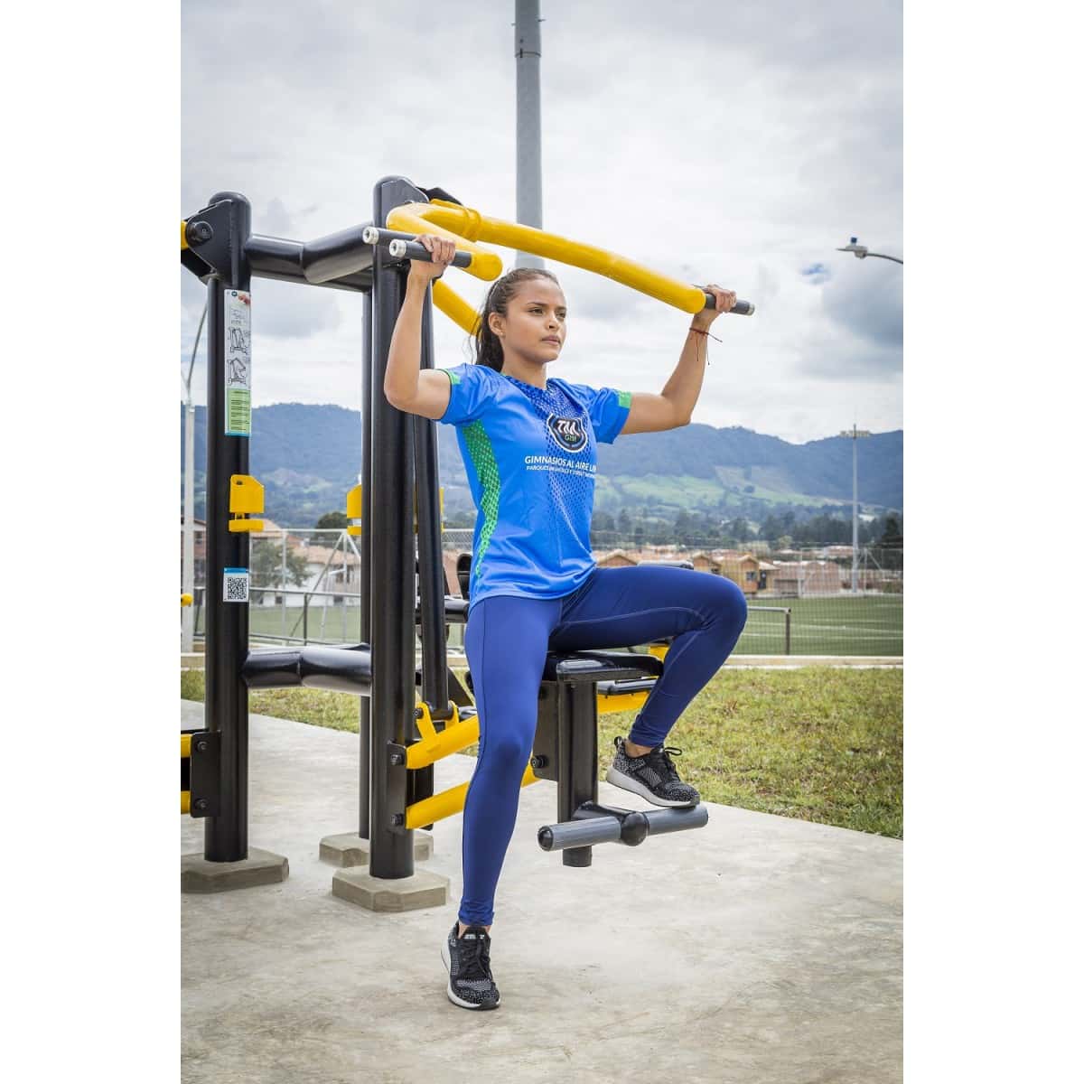 Mujer con los brazos arriba en el jalón de espalda doble de TMGYM