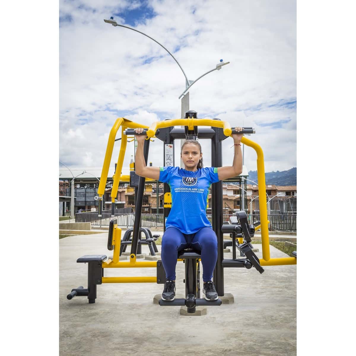 Mujer en el jalón de espalda doble de TMGYM, vista frontal