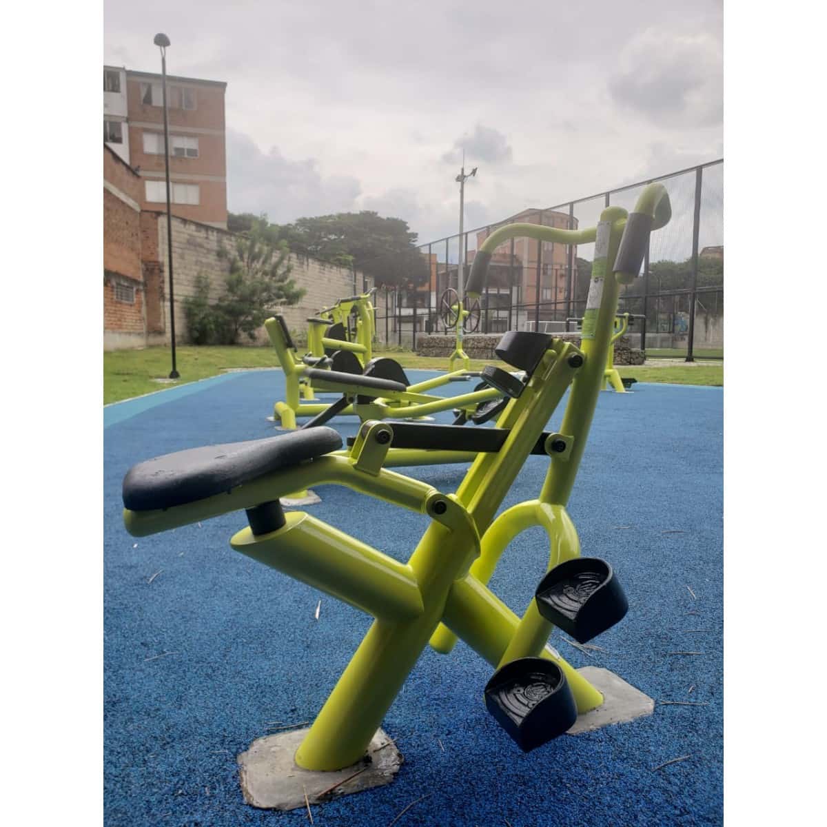 Jinete verde y amarillo de TMGYM sobre piso azul en un parque
