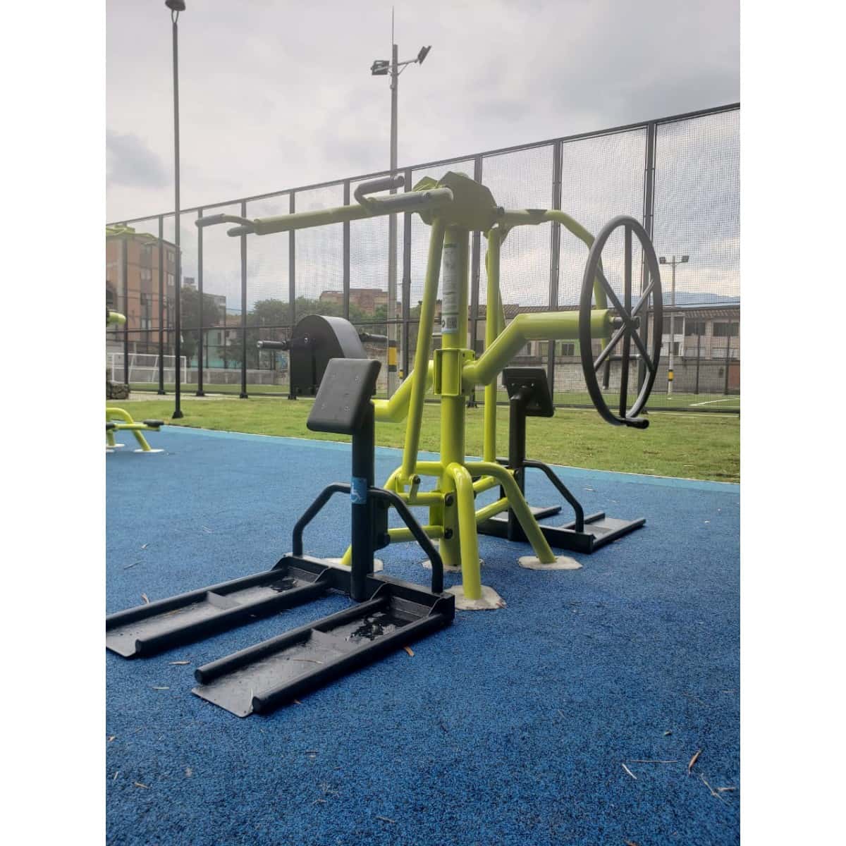 Estación multifuncional de TMGYM para movilidad reducida sobre piso azul, vista general