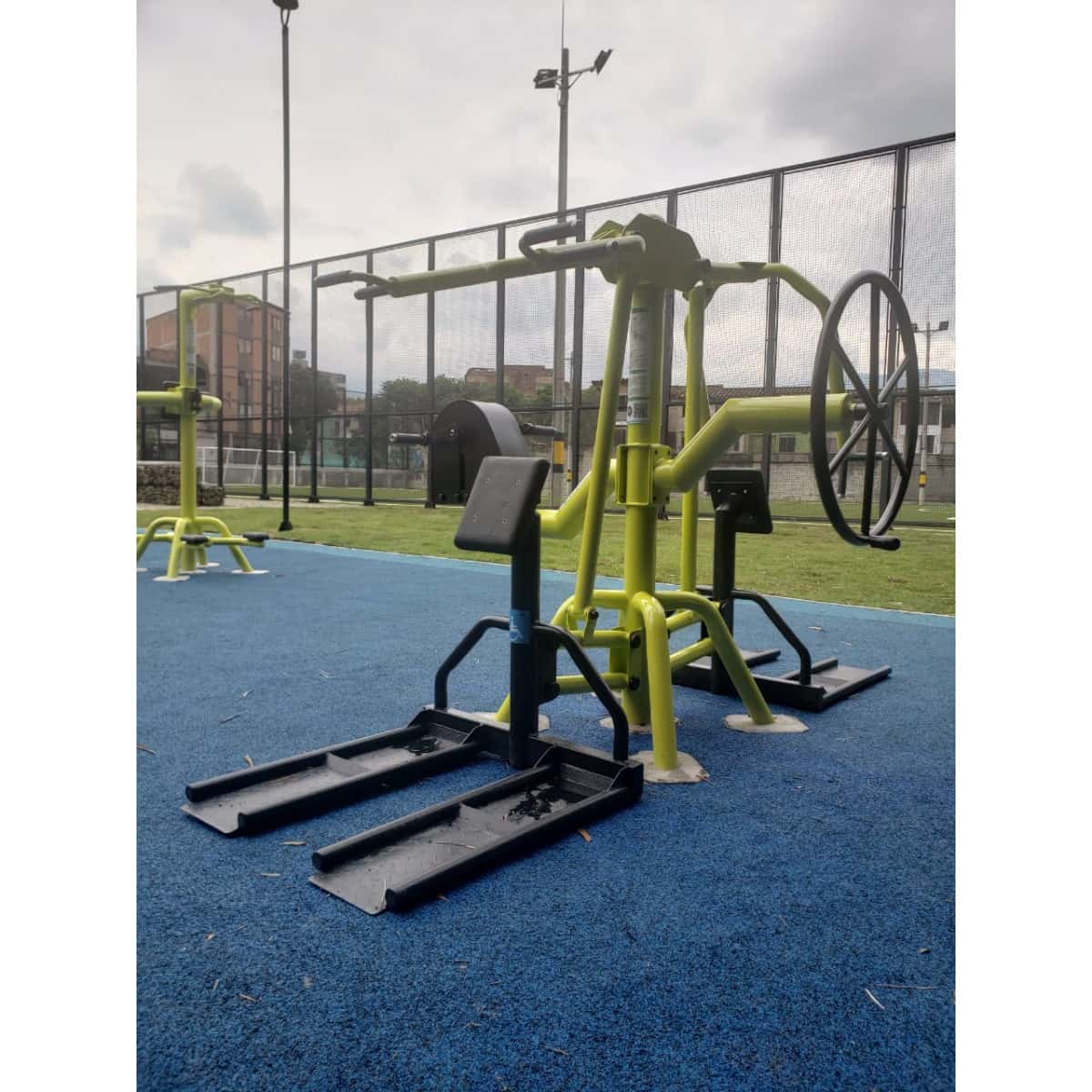 Estación multifuncional de TMGYM con rueda y plataformas sobre piso azul