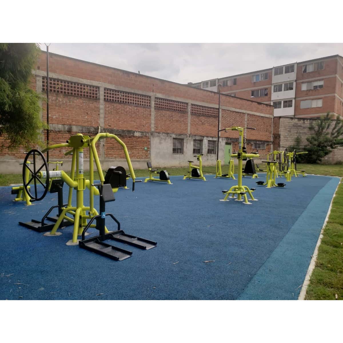 Estaciones multifuncionales de TMGYM en un parque con un edificio al fondo