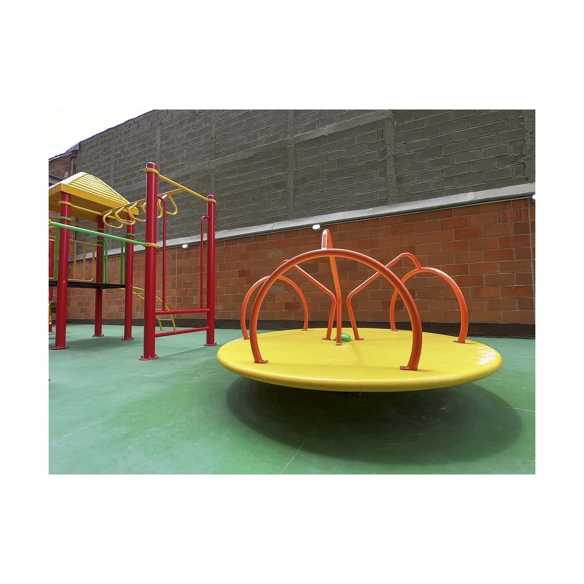 Carrusel amarillo con arcos naranjas en un parque infantil recreativo
