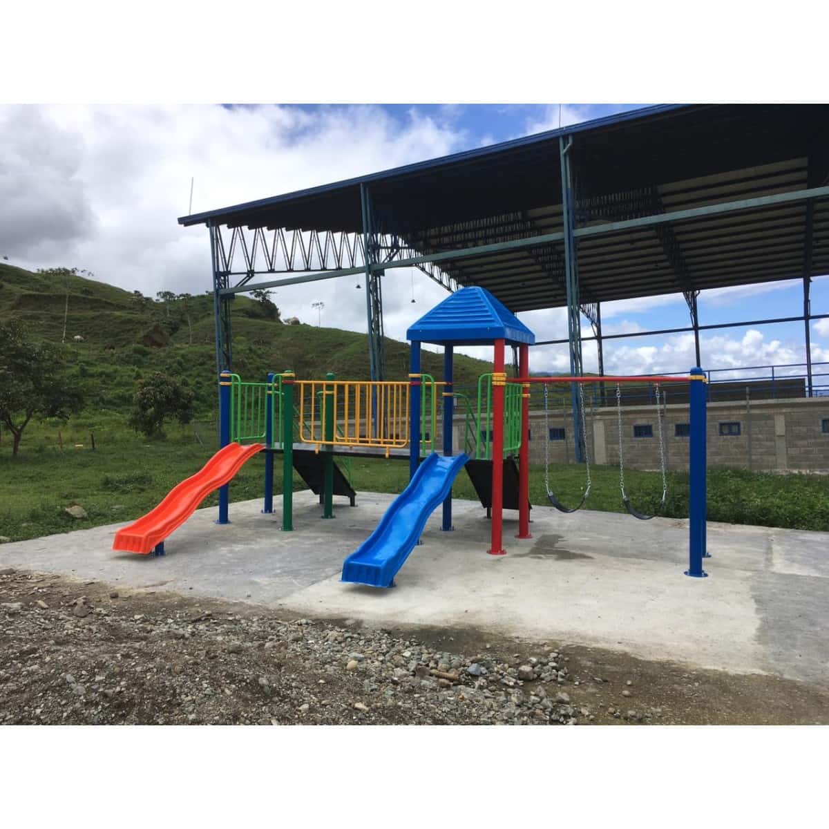 Parque infantil recreativo con deslizaderos, bajo una cubierta de techo metálico
