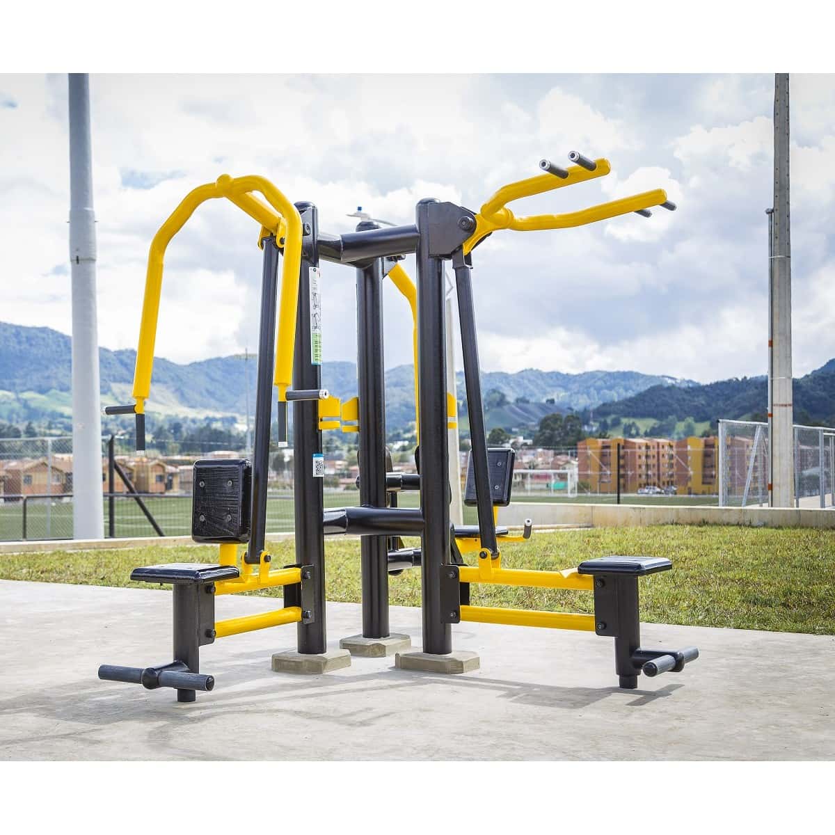 Triple de pecho, espalda y piernas de TMGYM, torre de fuerza amarilla y negra en un parque con montañas al fondo
