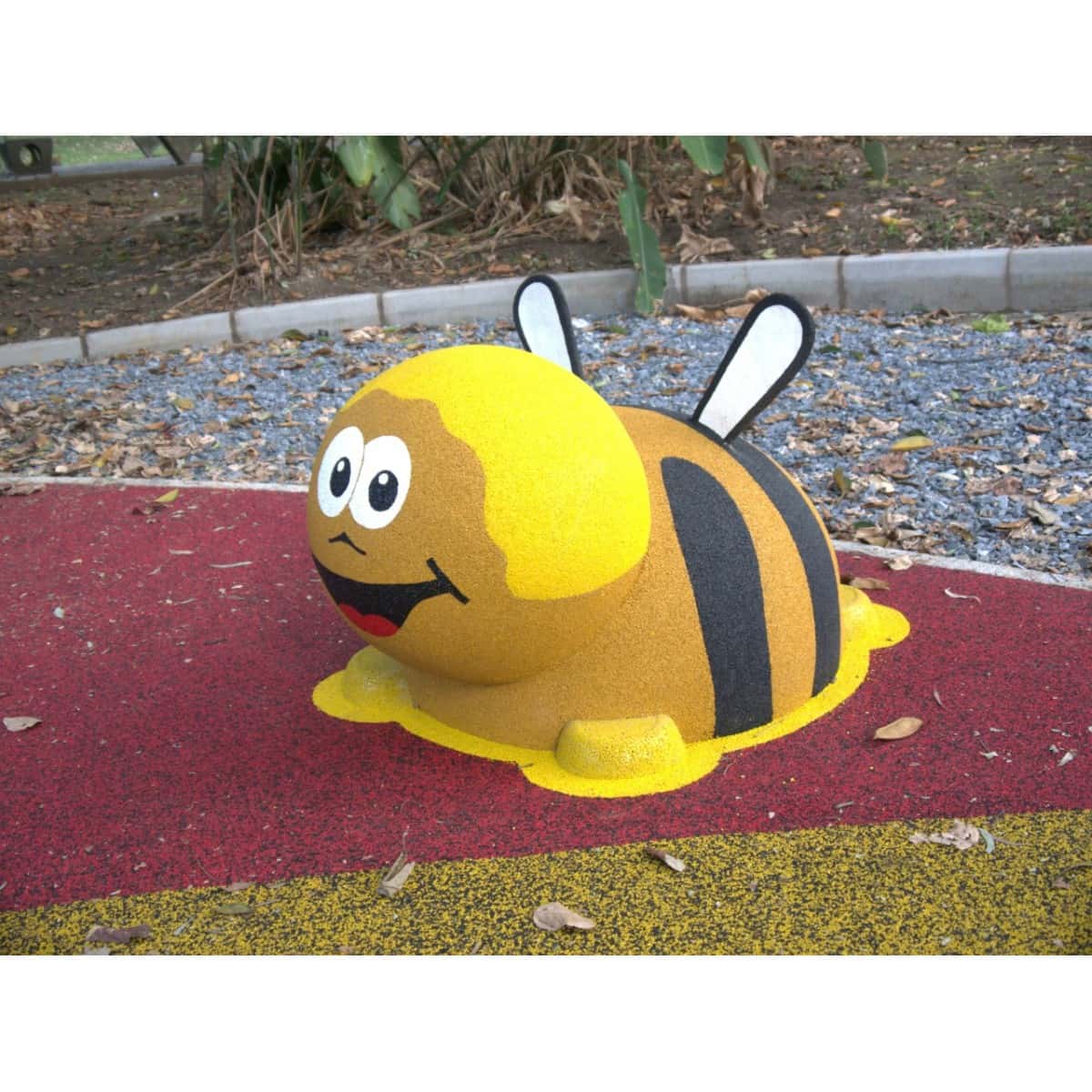 Figura 3D de abeja instalada sobre piso rojo de caucho en un parque