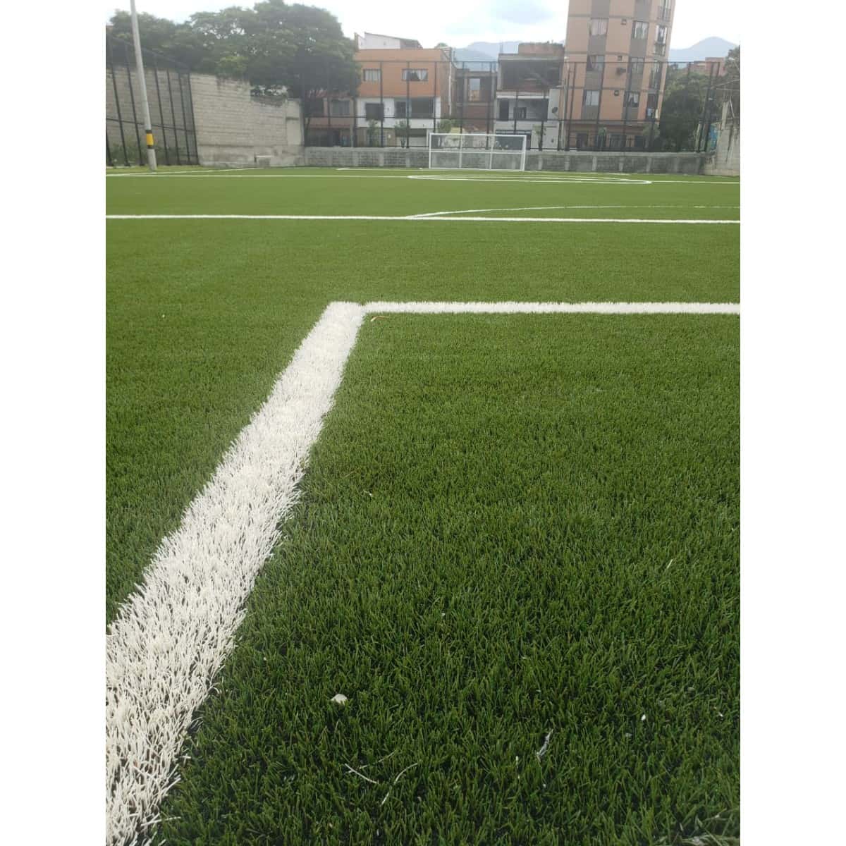 Línea blanca de demarcación sobre la grama sintética de una cancha de fútbol