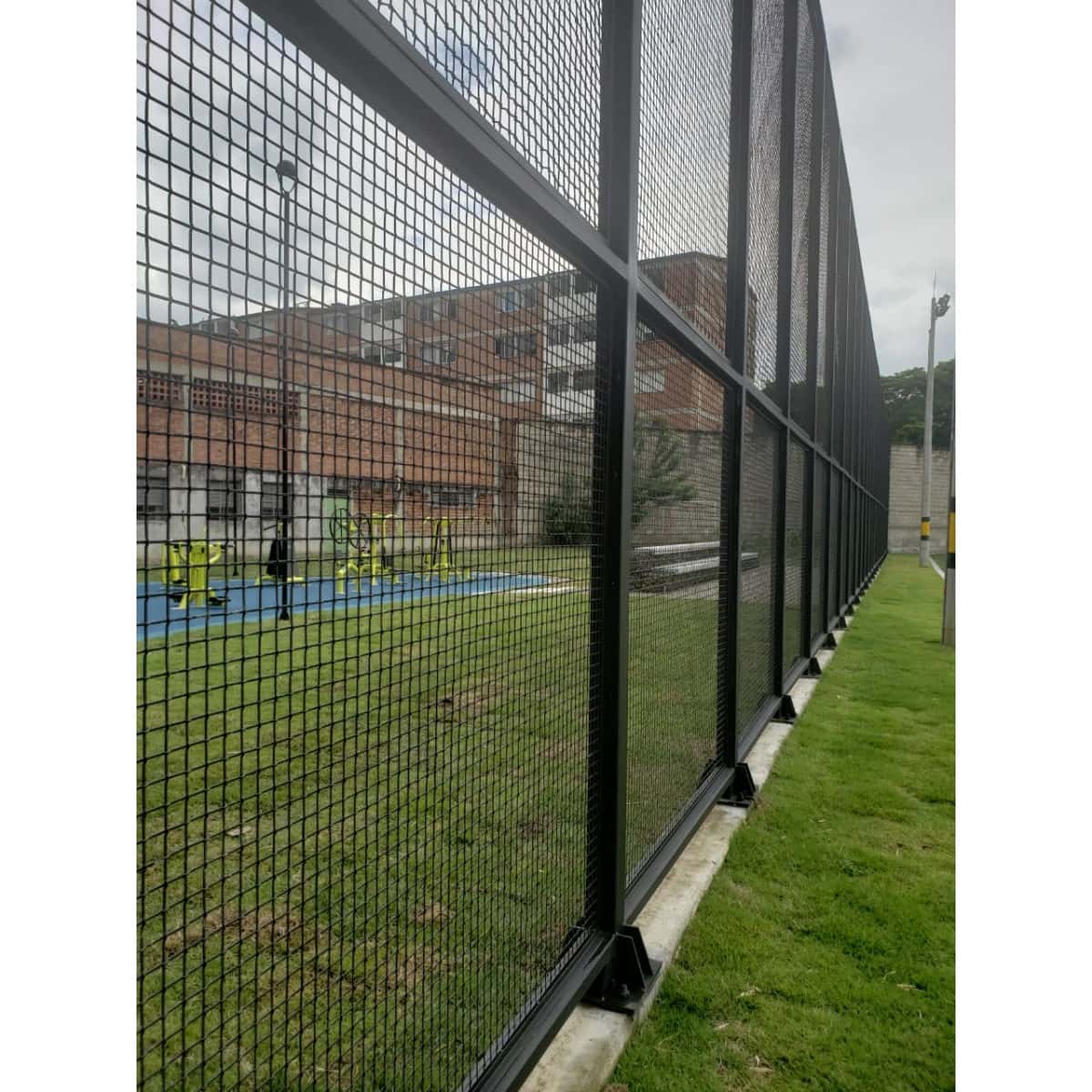 Cancha de grama sintética con cerramiento de malla negra