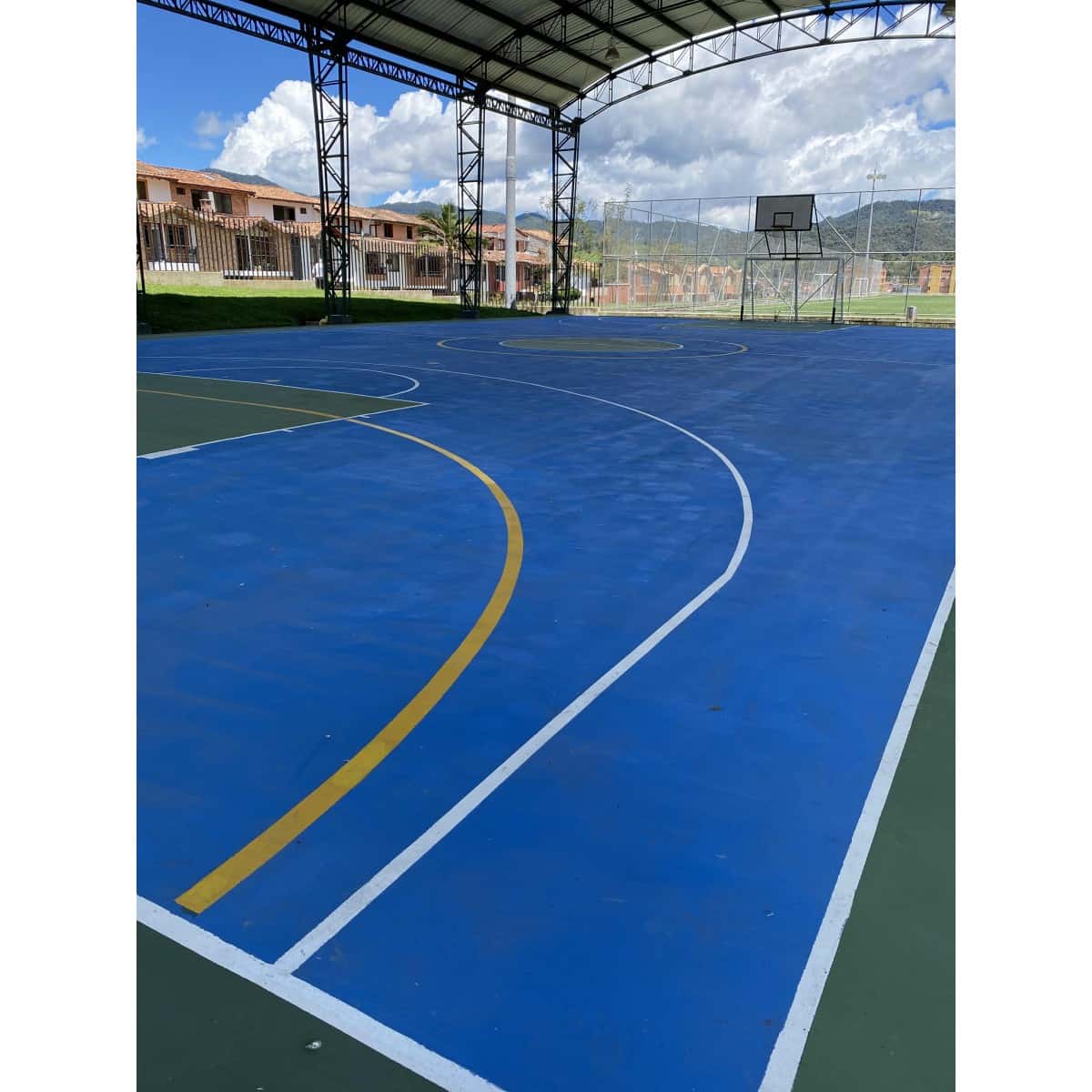 Cancha de coliseo pintada con líneas amarillas y blancas de demarcación