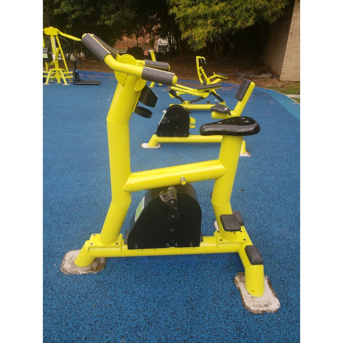 Bicicleta estática de TMGYM, equipo amarillo para parque sobre piso azul