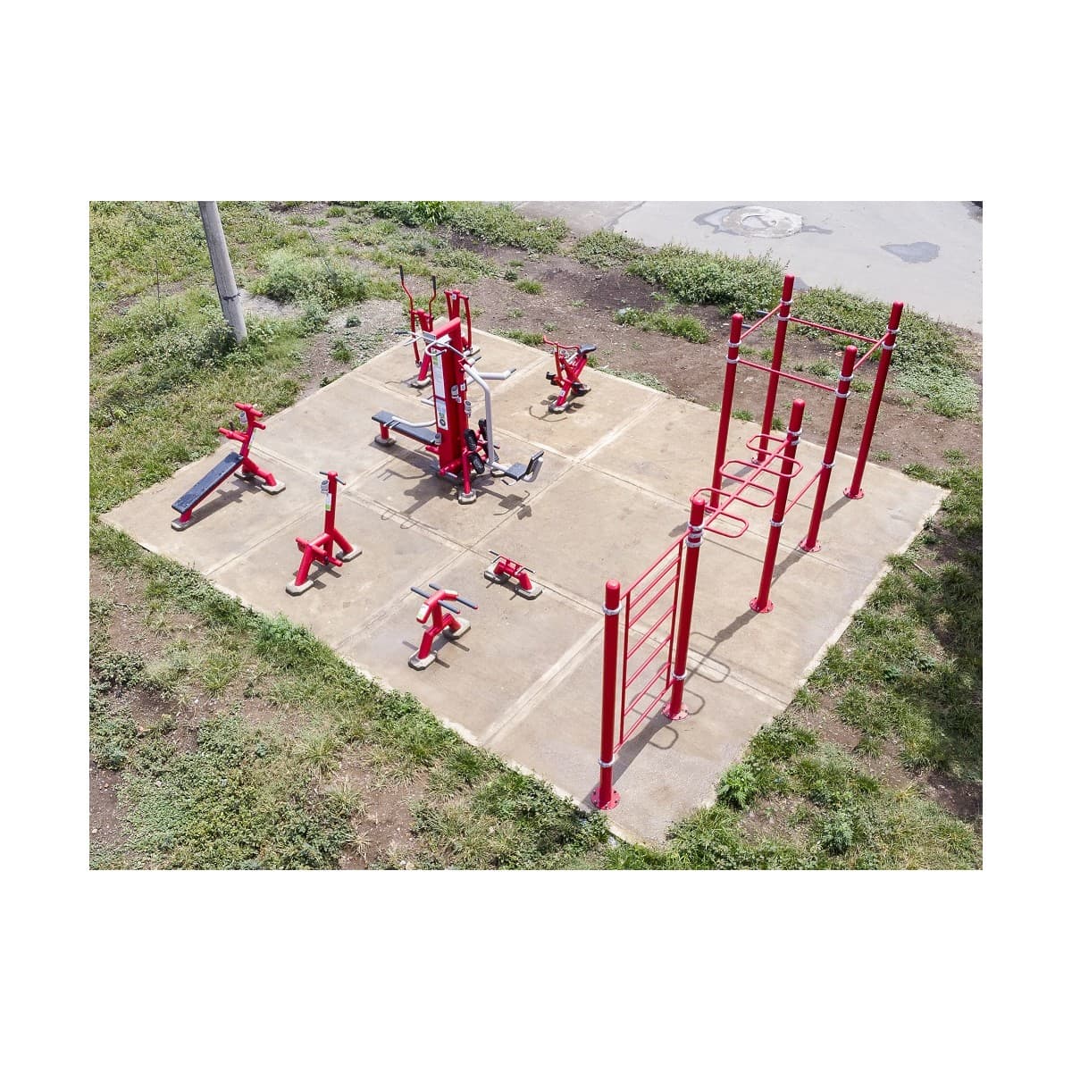 Vista aérea de un parque mixto de calistenia y fuerza de TMGYM, con estructuras rojas sobre una losa de concreto