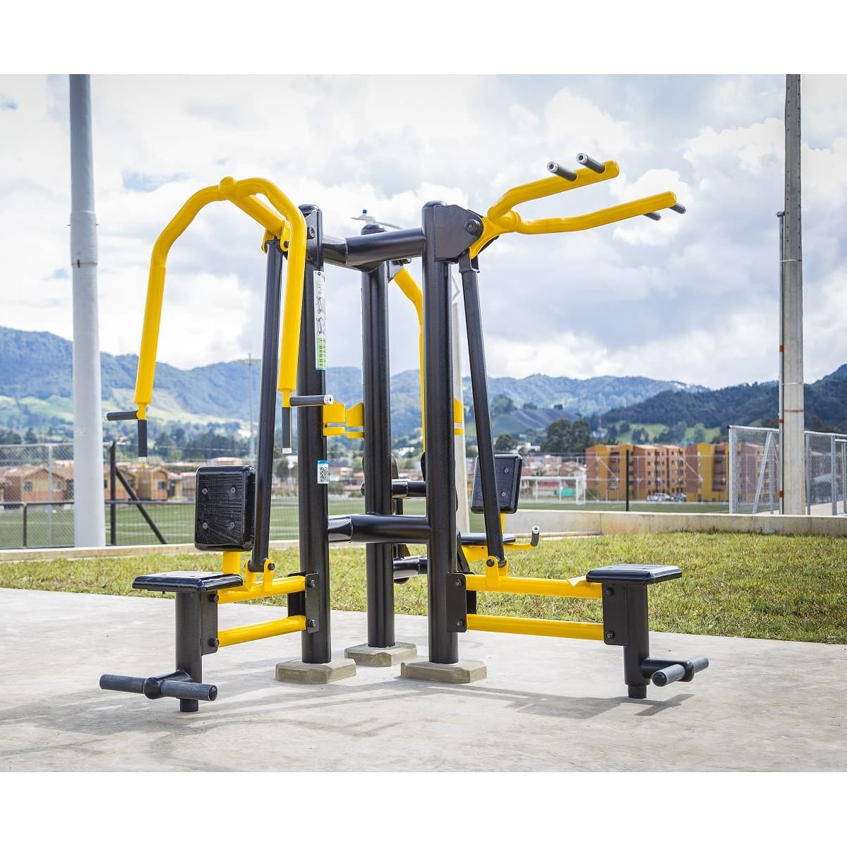 Triple de pecho, espalda y piernas de TMGYM, torre de fuerza amarilla y negra en un parque con montañas al fondo