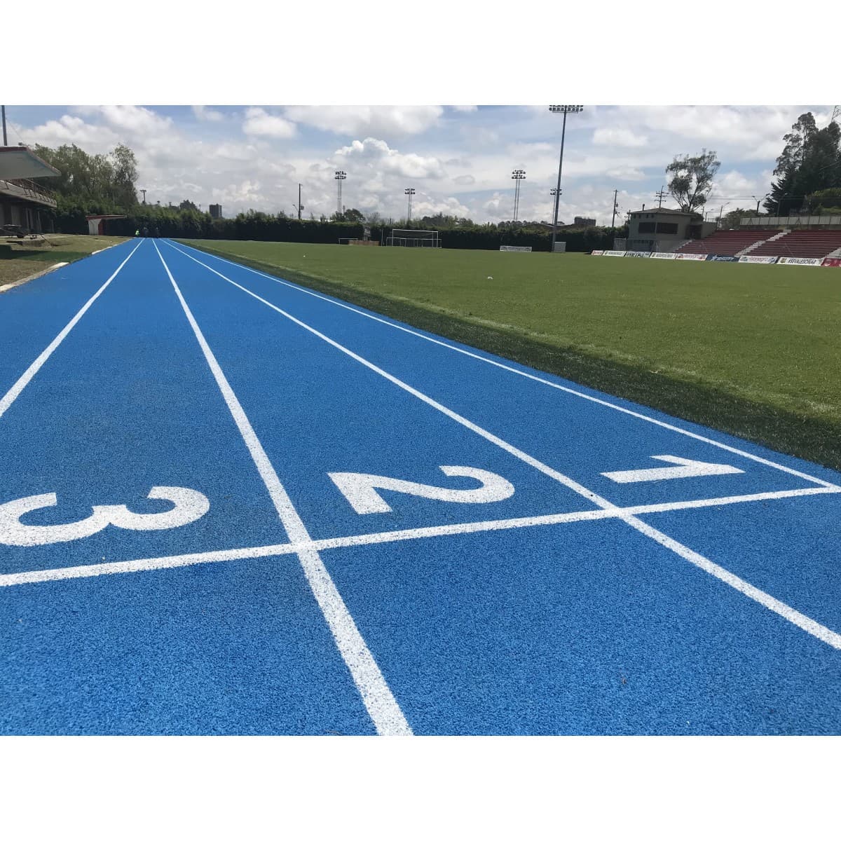 Pista de atletismo pintada en azul, con numeración de carriles
